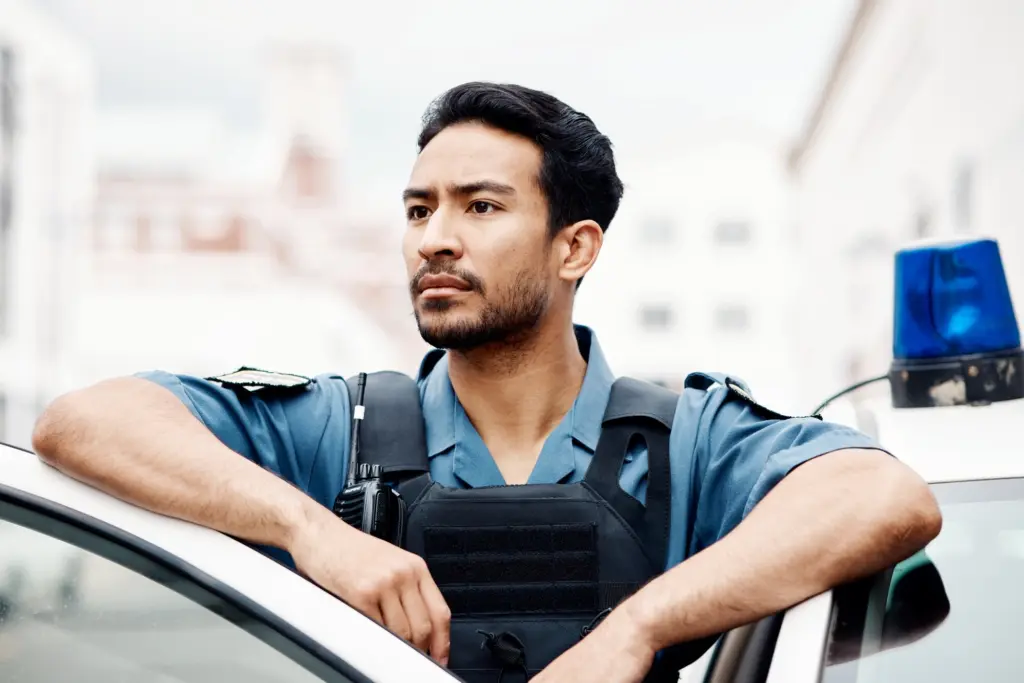 Police, thinking and man officer by a car for an investigation or patrol for law protection in city