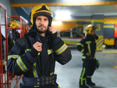A firefighter puts on a fire uniform at the fire department