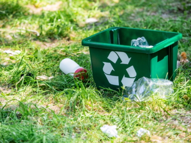 recycling box and plastic trash on green grass