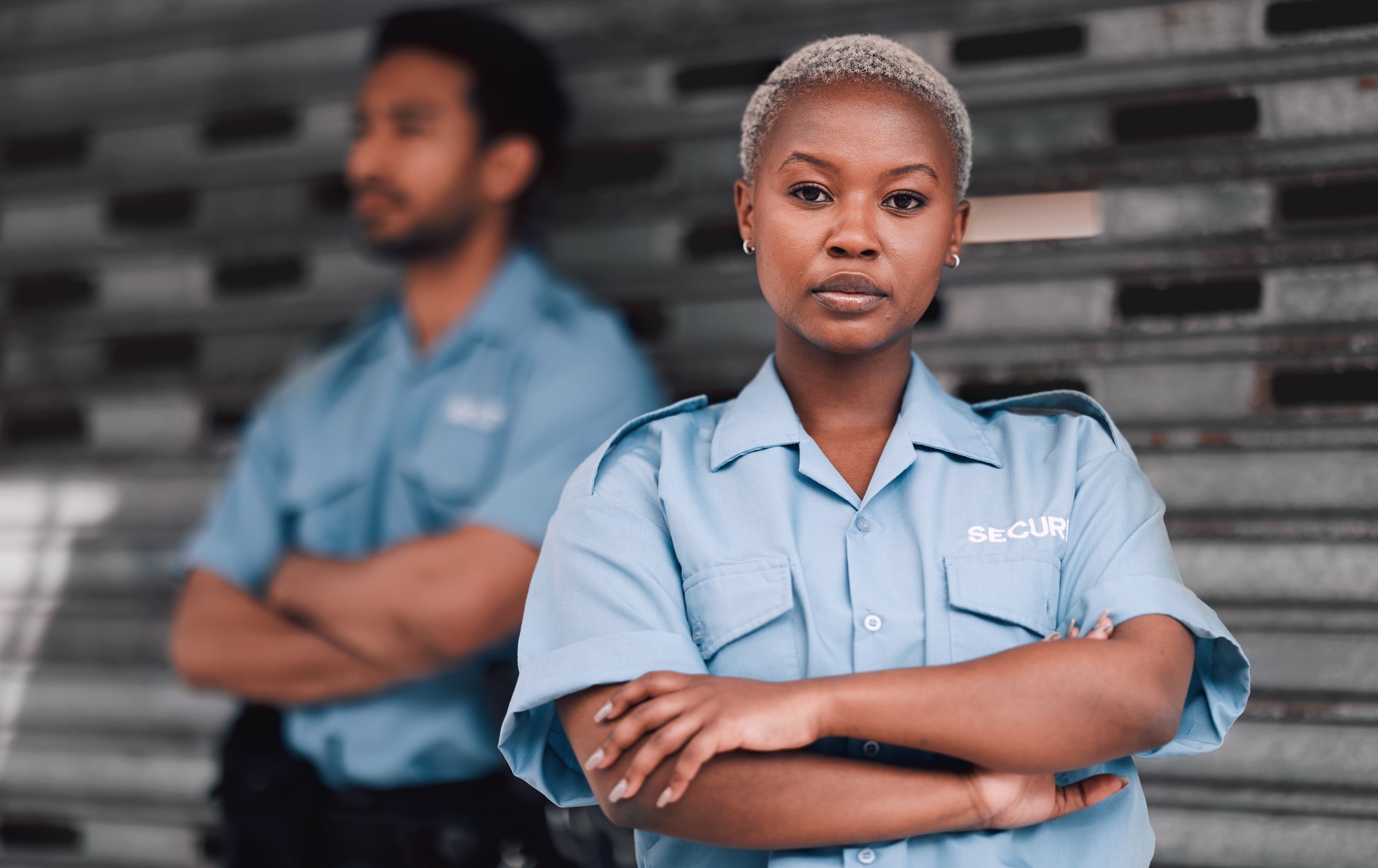 Portrait, security or law enforcement and a serious woman arms crossed with a man colleague on the