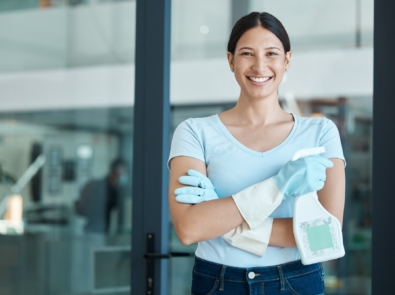Cleaning service, portrait and cleaner in an office with spray bottle of disinfectant, bleach or de